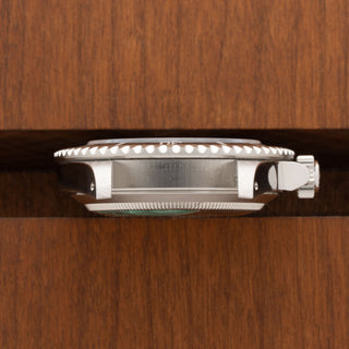 Horizontal profile detail showing the sharp crown guards and Triplock winding crown of a Rolex 14060M