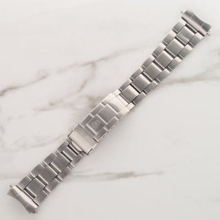 Top view of the stainless steel folded-link Oyster bracelet detached from the case of a Rolex Submariner 5513