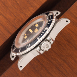 Angled top perspective showcasing the acrylic crystal, signed winding crown, and thick lug proportions on a Rolex 5513