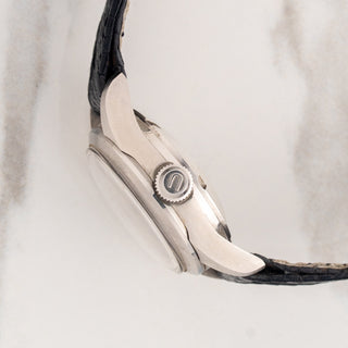 Side profile view showcasing the signed winding crown and twisted lugs on an unpolished ladies Universal Genève Polerouter