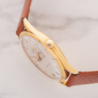 Side view displaying the signed winding crown and gold case proportions of a vintage Universal Genève 1509623