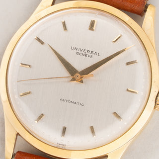Macro close-up shot of the silver dial, gold dauphine hands, and lapped hour markers on a Universal Genève 1509623