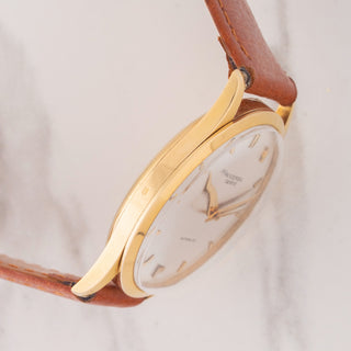 Side profile view showcasing the slim 18k gold case lines and long curved lugs of a Universal Genève dress watch