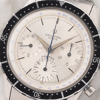 Macro close-up of the silver sunburst chronograph dial, sub-registers, and tritium lume plots on a Universal Genève Compax 22703