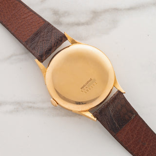 Solid 18k pink gold caseback showing crisp reference and serial number engravings on a vintage Universal Genève Monodatic