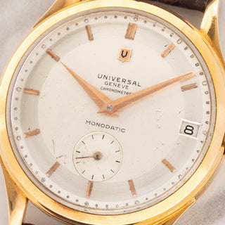 Macro close-up shot of the rare two-tone Chronomètre dial, dauphine hands, small seconds subdial, and date window on a Universal Genève Monodatic