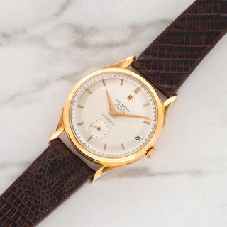 1950s Universal Genève Monodatic reference 100101 in 18k pink gold with two-tone Chronomètre dial on a dark brown leather strap at Collectors Corner NY