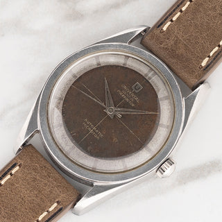 Angled shot highlighting the stainless steel twisted lugs and tropical chocolate crosshair dial on a Universal Genève Polerouter