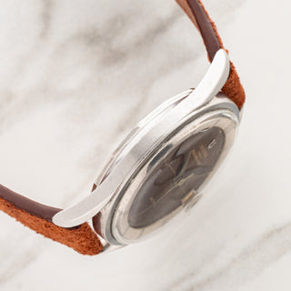 Side profile view displaying the Gérald Genta designed bombé lug geometry on a vintage Universal Genève Polerouter Date