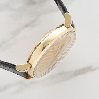 Side profile displaying the clean 18k yellow gold case lines and thick lugs of a vintage UG Polerouter