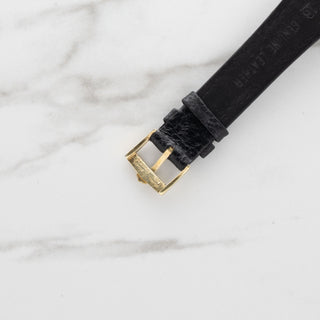 Underside view showing the 18k gold hallmarks on an authentic vintage Universal Genève watch strap buckle.