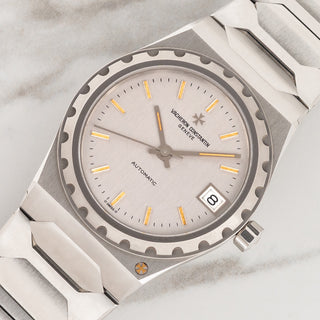 Angled shot highlighting the notched bezel, integrated case, and gold Maltese cross emblem on a Vacheron Constantin 222