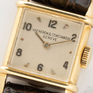 Macro close-up of the raised enamel Vacheron Constantin logo and Arabic numeral markers on a vintage 1940s dial
