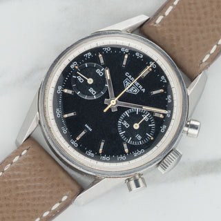 Angled shot highlighting the sharp unpolished case lugs and black tachyring dial of a 1963 Heuer Carrera 3647NT