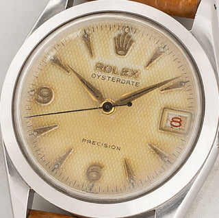Close-up shot of the rare tropical patina waffle dial and red roulette date wheel on a vintage Rolex Oysterdate reference 6466