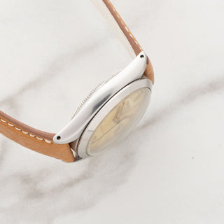 side profile view showcasing the clean stainless steel case finish and even lugs of a vintage Rolex Oysterdate