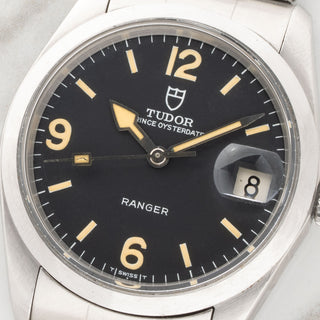 Macro close-up view of the mint matte black Explorer-style dial and warm yellow tritium lume on a 1977 Tudor Ranger Date