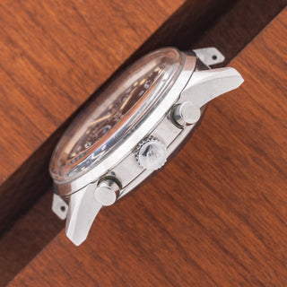 Angled top perspective showcasing the domed acrylic crystal, unpolished case lines, and winding crown on a Wittnauer 242T
